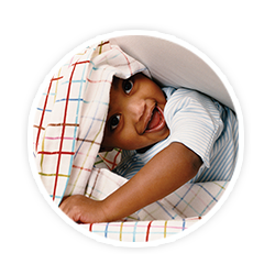 toddler boy peaking out from under blanket